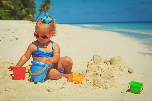 Cute little girl playing with sand on beach — Stock Photo, Image