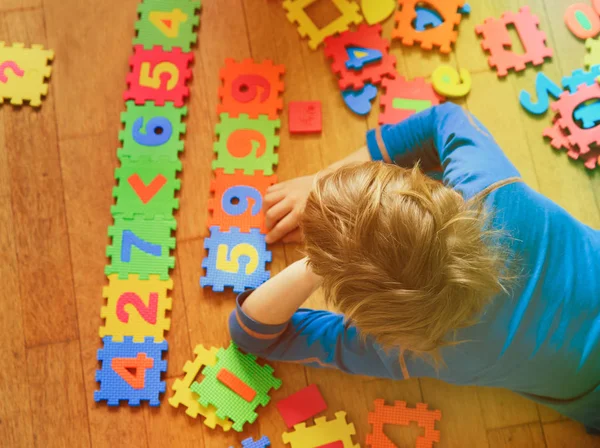 Liten pojke lär dig nummer spela med pussel — Stockfoto