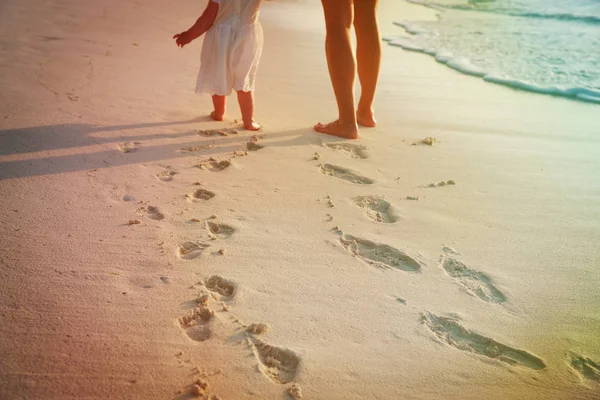Mère et fille marchant sur la plage laissant une empreinte dans le sable — Photo