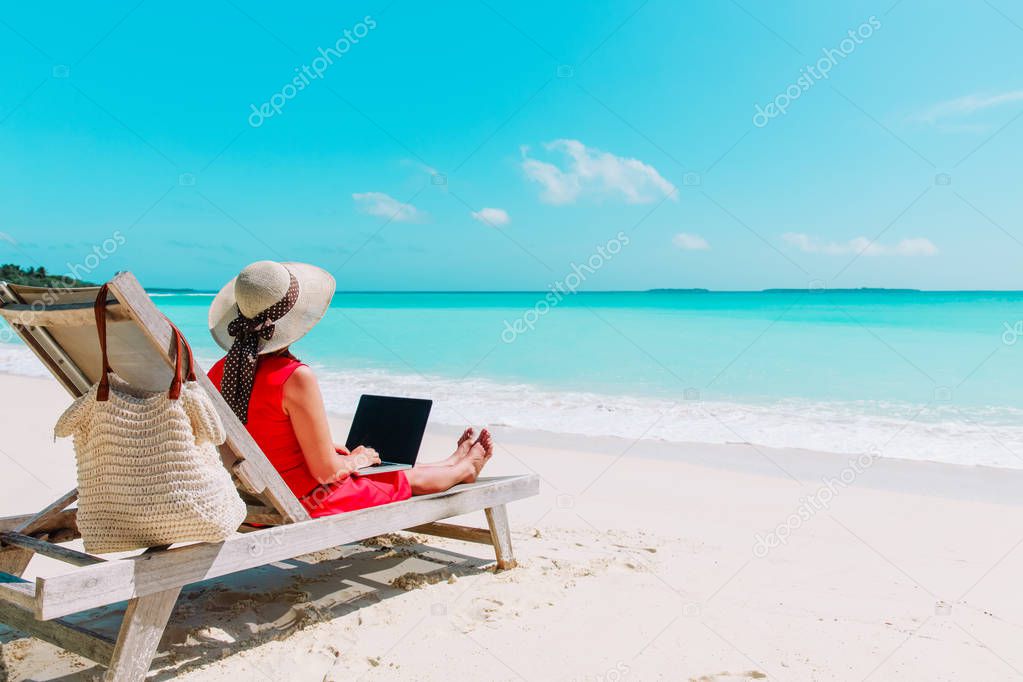 young woman with laptop on tropical beach