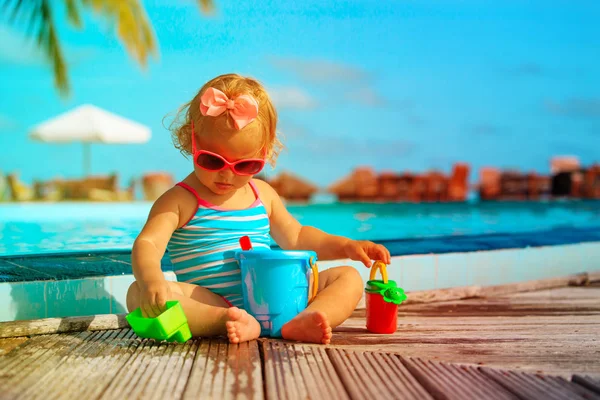 Schattig klein meisje spelen met water op tropisch strand — Stockfoto