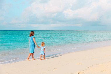 Anne ve küçük kızı sahilde yürüyor.