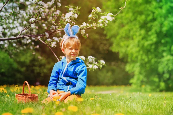 Bonito menino feliz na Páscoa ovos caçar na primavera — Fotografia de Stock