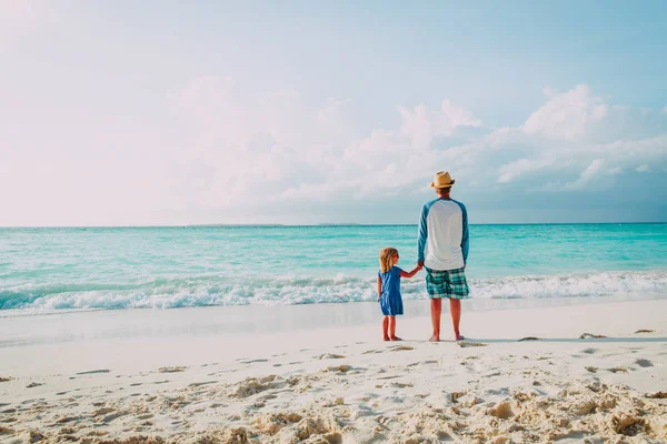 Vader en dochtertje wandelen op strand — Stockfoto