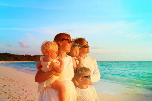 Família feliz com três crianças na praia tropical — Fotografia de Stock