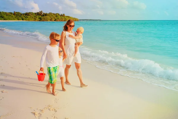 Moeder met zoon en dochters lopen op strand — Stockfoto