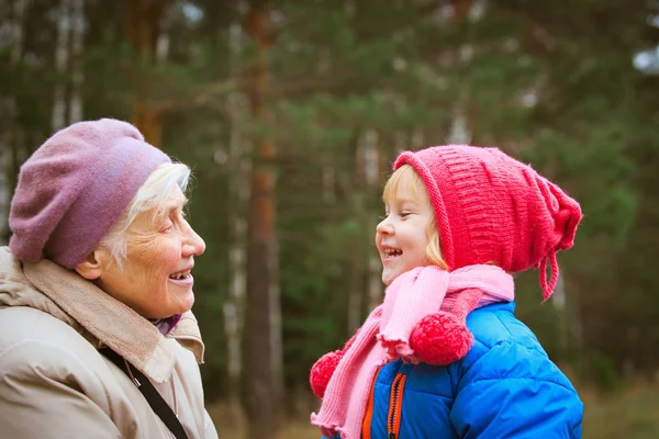 Happy grandmother and granddaughter talk in nature — Stock Photo, Image