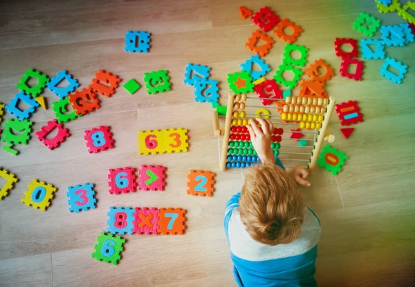 Liten pojke beräkna på abacus, spela med nummer pussel — Stockfoto