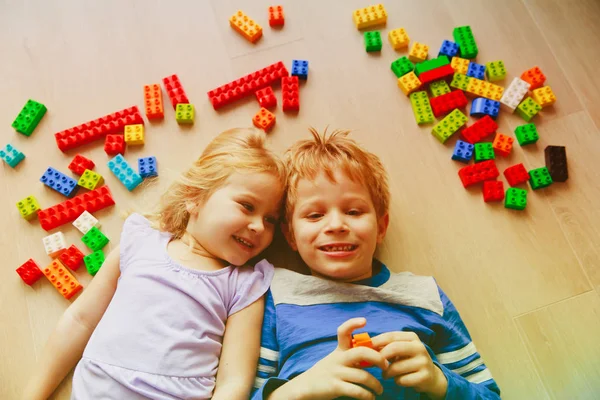 Cute anak laki-laki dan gadis bermain dengan blok plastik — Stok Foto