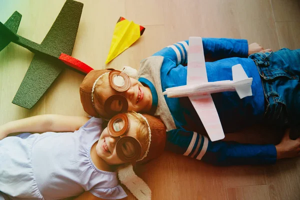 Glückliche Kinder mit Helm und Brille spielen mit Spielzeugflugzeug — Stockfoto