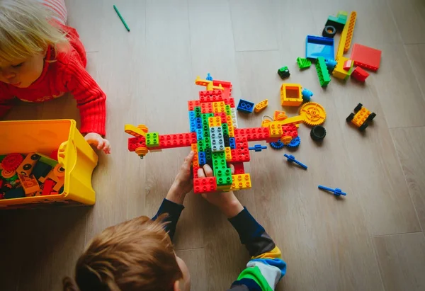 Menino e menina brincam com blocos de plástico — Fotografia de Stock