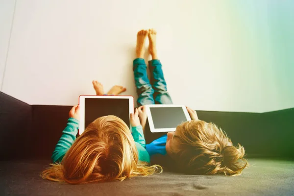 Kleine Jungen und Mädchen schauen zu Hause auf Touchpad — Stockfoto