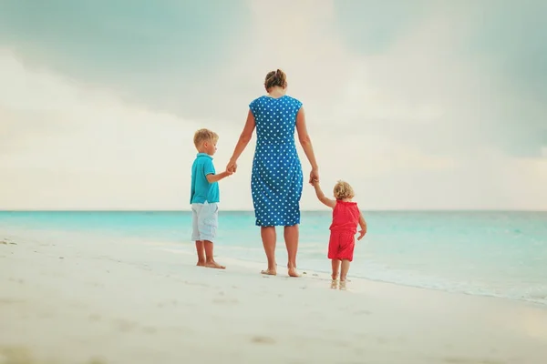Мать и двое детей прогуливаются по пляжу — стоковое фото