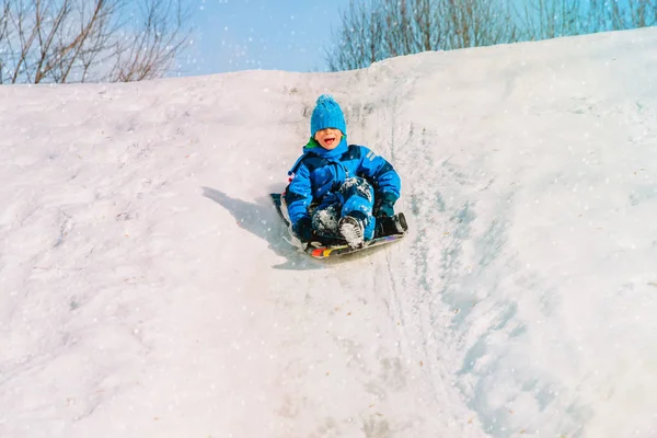 Kış eğlence - çocuklar karda kayan küçük çocuk — Stok fotoğraf