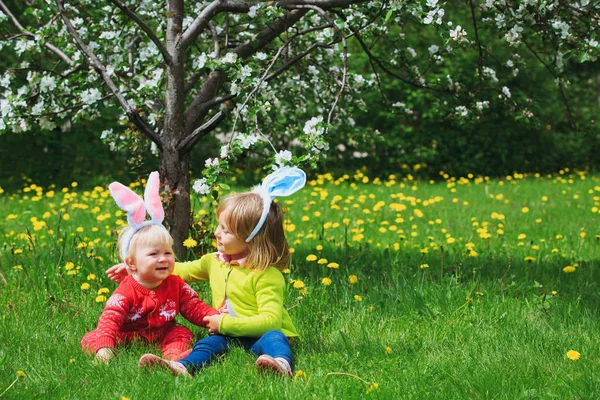 Niños felices en la caza de huevos de Pascua en primavera — Foto de Stock