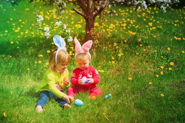 Crianças felizes em ovos de Páscoa caçam na primavera — Fotografia de Stock