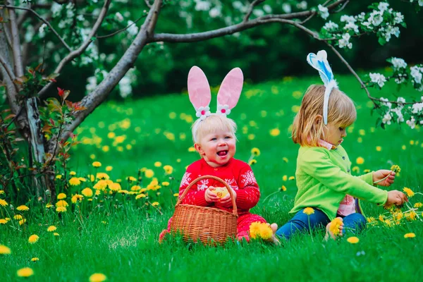 Crianças felizes em ovos de Páscoa caçam na primavera — Fotografia de Stock