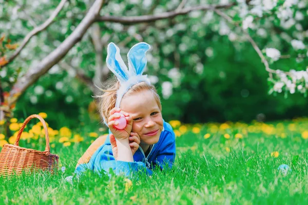 Lindo niño feliz en la caza de huevos de Pascua en primavera — Foto de Stock