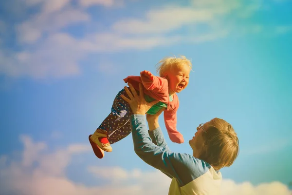 Far och glada lilla dotter spela på sky — Stockfoto