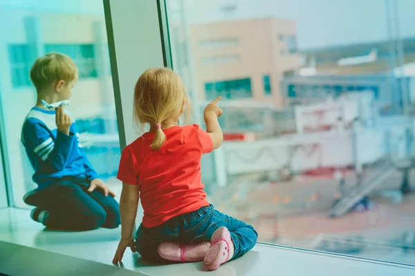 Liten pojke och flicka väntar plan i flygplats — Stockfoto