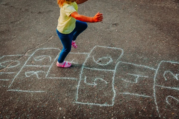 Menina jogar hopscotch no playground — Fotografia de Stock