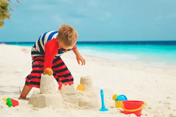 Kisfiú játszani homok a strandon — Stock Fotó