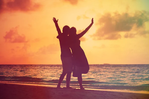 Glad romantiska par på stranden vid solnedgången — Stockfoto