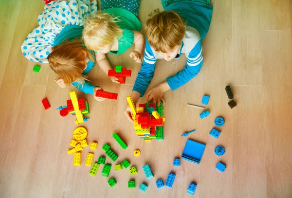 Niños juegan construcción con bloques de plástico — Foto de Stock