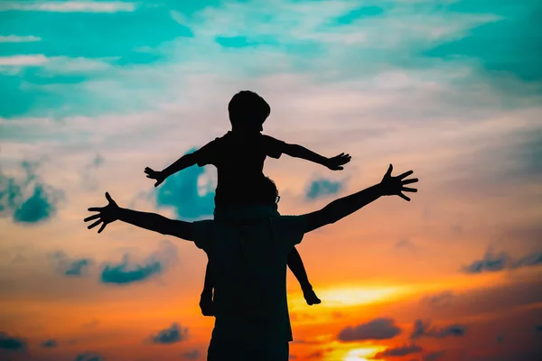 Père et fils jouent sur le ciel couchant — Photo