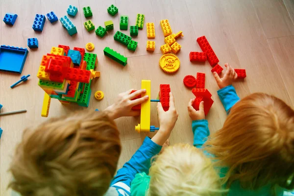Crianças brincam de construção com blocos de plástico — Fotografia de Stock