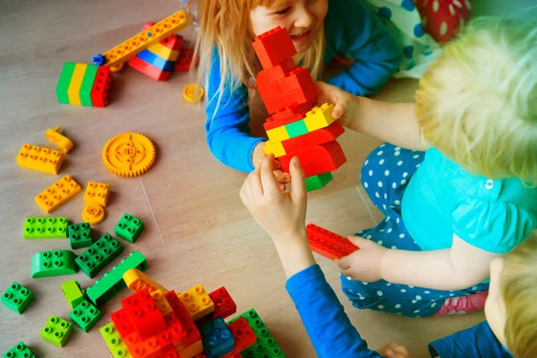 Enfants jouent construire avec des blocs en plastique à l'intérieur — Photo