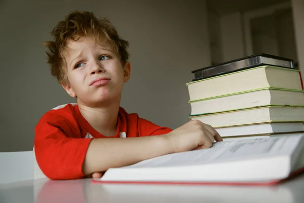 Pequeño niño cansado estresado de leer, haciendo la tarea —  Fotos de Stock