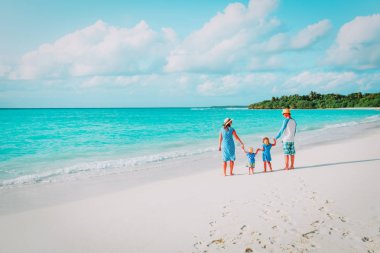 İki çocuklu mutlu aile tropik sahilde yürümek