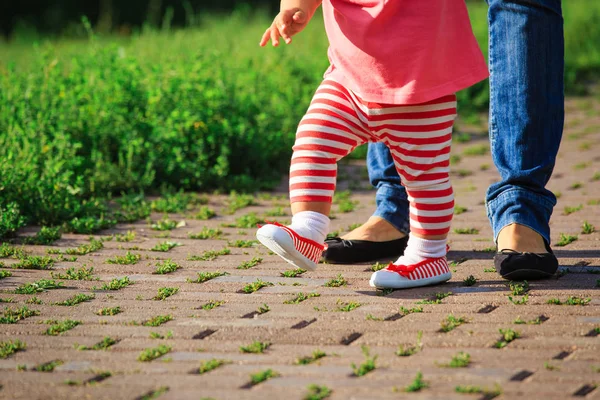 Primeiros passos da menina bonito com a mãe na natureza — Fotografia de Stock