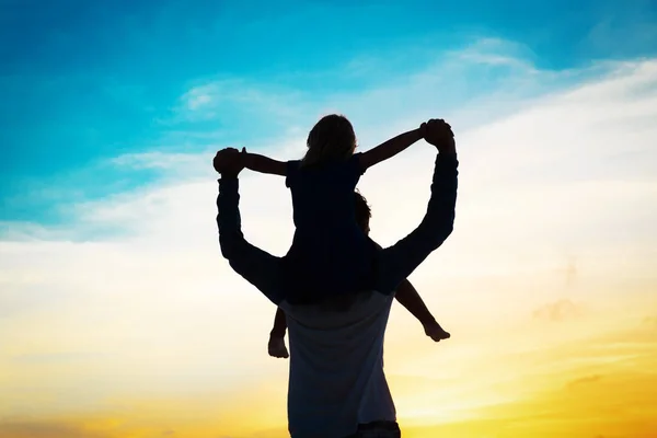 Père et petite fille sur les épaules jouent au coucher du soleil ciel — Photo