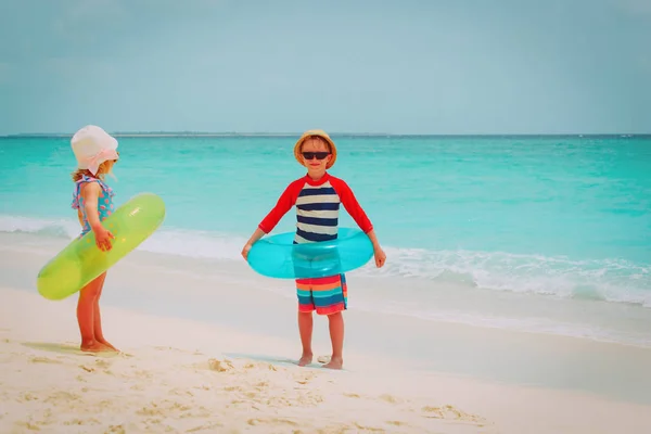 Mała dziewczynka i chłopiec iść pływać na plaży — Zdjęcie stockowe