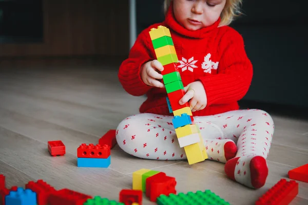 Pequeno bebê brincando com blocos de plástico coloridos — Fotografia de Stock