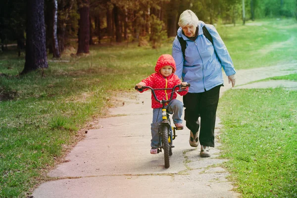 Avó ensinando neta a andar de bicicleta — Fotografia de Stock