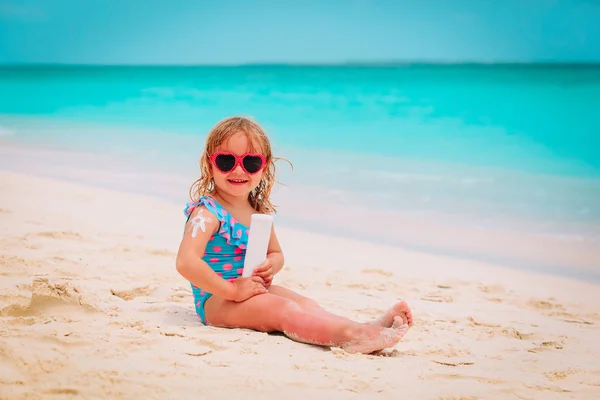 Solskydd på stranden - lilla flicka tillämpa sunblock grädde på axel — Stockfoto