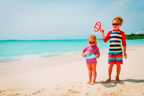 Malý chlapec a dívka hrát plážový tenis na dovolené — Stock fotografie