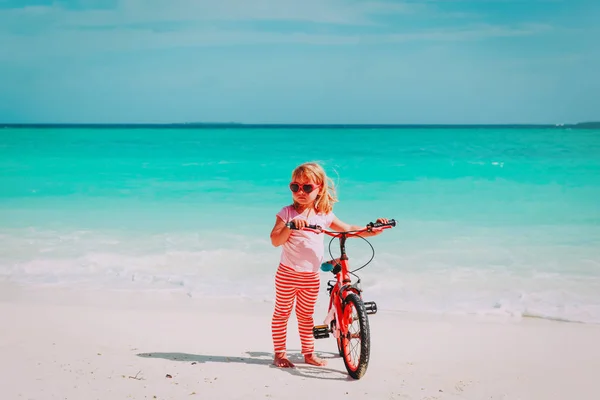 Linda niña montar en bicicleta en la playa —  Fotos de Stock