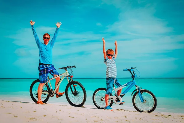 Щасливий батько і син і велосипед на пляжі — стокове фото