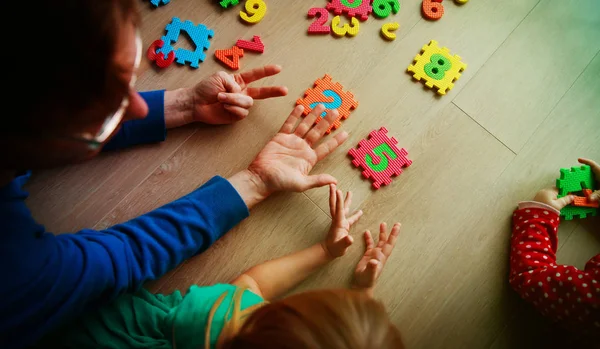 Učitel a děti hrát s číslo puzzle — Stock fotografie