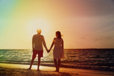 Gün batımında tropik sahilde romantik Çift