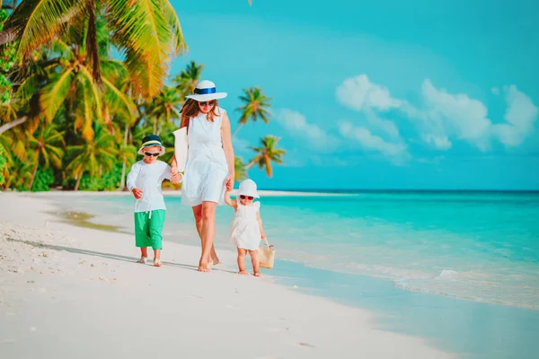 Moeder met kleine zoon en dochter wandeling op strand — Stockfoto