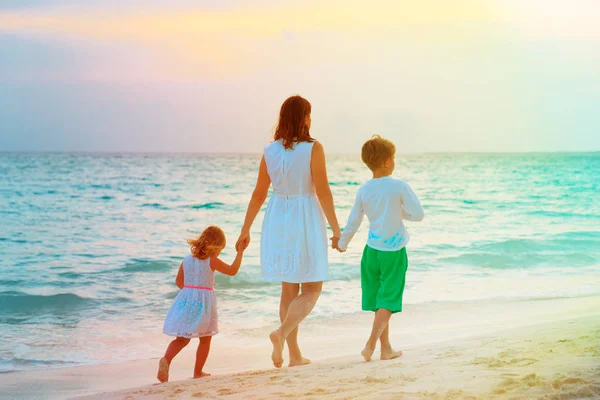 Mère et deux enfants marchant sur la plage — Photo