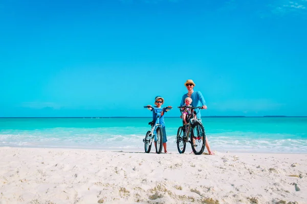 작은 아들과 딸 비치에 자전거와 아버지 — 스톡 사진