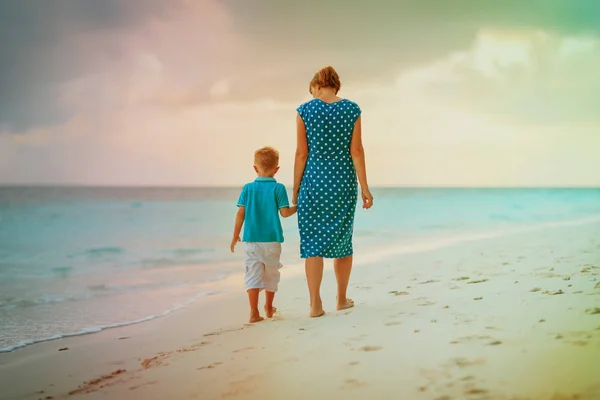 Mère et fils marchant sur la plage du coucher du soleil — Photo