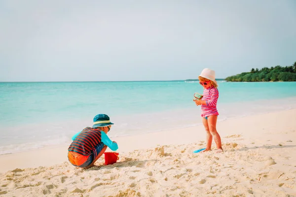 Kleine jongen en meisje spelen met zand op het strand — Stockfoto