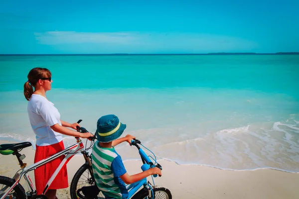 Boldog anya és fia kerékpározás a strandon — Stock Fotó